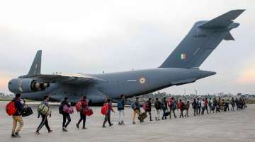 Stranded Kashmir bound passengers queue up to board a C-17 aircraft of the Indian Air Force 
