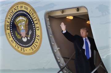 US President Donald Trump waves while boarding Air Force One for a trip to Vietnam to meet with Nort