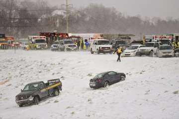 Emergency responders help victims from their cars after a multi car pile up after a snow squall in Wyomissing, Pa.