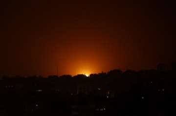 An explosion caused by Israeli airstrikes is seen on Gaza City, early Friday.
