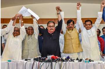Rashtriya Janata Dal MP Manoj Jha, state's party President Ramchandra Purbey and Congress' state president Madan Mohan Jha join hands after announcing the grand alliance's candidates list for upcoming Lok Sabha election 2019, in Patna