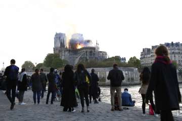?Flames and smoke rise from Notre Dame cathedral as it burns in Paris