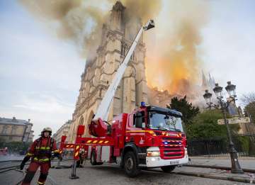 This photo provided on Tuesday April 16, 2019 by the Paris Fire Brigade shows fire fighters working 