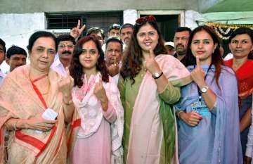 Beed: Maharashtra Women and Child Welfare Minister Pankaja Munde, BJP candidate Pritam Munde and others voters show their fingers, marked with indelible ink, after casting votes at a polling station, during the 2nd phase of Lok Sabha elections 