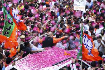 BJP President Amit Shah is showered with flower petals as he arrives at the party office in new Delhi, India, Thursday, May 23, 2019.?