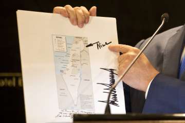 Prime Minister of Israel, Benjamin Netanyahu pointing at Donald Trump's note on a map of Israel