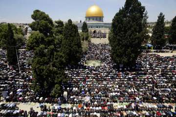 Palestinians pray in front of the Dome of the Rock shrine during a holy month of Ramadan, in Jerusal