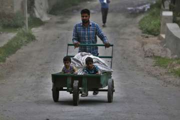 A Kashmiri farmer pushes a handcart with children on it on the outskirts of Srinagar, Indian controlled Kashmir.