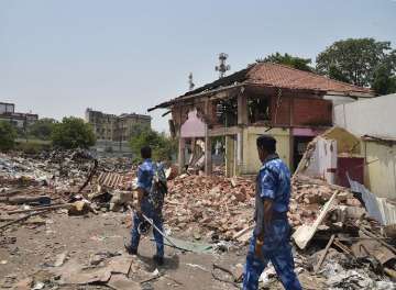Security personnel make way through the debris of demolition structures at the British-era Gole Market, in Patna