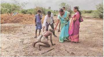 Kasi falling at he feet of officials who had come to rescue the bonded labourers