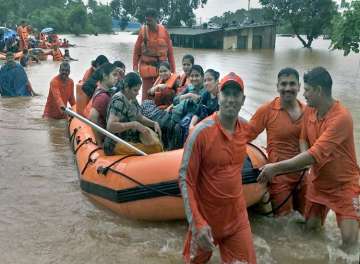 NDRF personnel carry out rescue and relief operation after a train bound for Kohlapur from Mumbai was stranded following heavy monsoon rain near Badlapur in Thane district