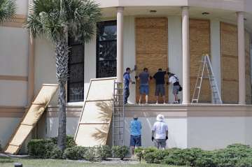 Workers cover stained glass windows with plywood sections at the Santa Maria del Mar Catholic Church