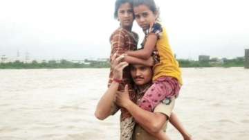 Heroic rescue: Gujarat cop carries two girls on his shoulder, wades through floodwater for 1.5 kms | Watch