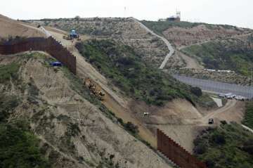 Construction crews replace a section of the primary wall separating San Diego, above right, and Tijuana, Mexico, below left, seen from Tijuana, Mexico. Defense Secretary Mark Esper has approved the use of $3.6 billion in funding from military construction projects to build 175 miles of President Donald Trump’s wall along the Mexican border. 