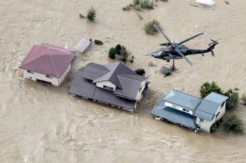 A Japan Self-Defense Force helicopter hovers above submerged residential area after an embankment of the Chikuma River.