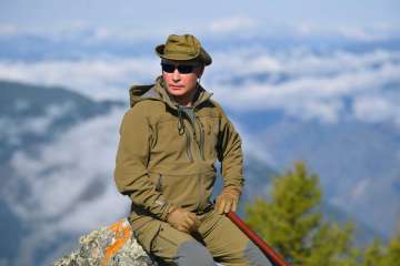 Russian President Vladimir Putin rests on a hill in Siberia during a break from state affairs ahead of his birthday. Russian president chose the Siberian taiga forest to go on a hike ahead of his birthday on Oct. 7.