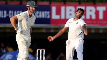 South Africa's Theunis de Bruyn, left, watches as India's Ravichandran Ashwin bowls a delivery during the third day of third and last cricket test match between India and South Africa in Ranchi, India