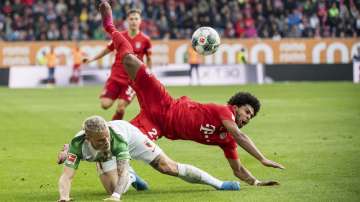 Augsburg's Philipp Max and Munich's Serge Gnabry challenge for the ball during a German Bundesliga soccer match between FC Augsburg and Bayern Munich in Augsburg, Germany, Saturday