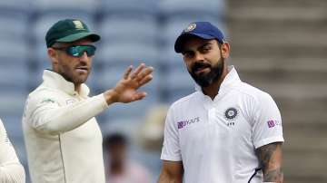 India's cricketer Virat Kohli and South Africa's Faf du Plessis interact on the field during the second day of the second cricket test match between India and South Africa in Pune