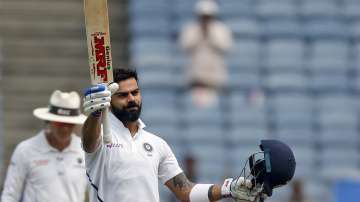 Indian cricketer Virat Kohli celebrates after scoring a century during the second day of the second cricket test match between India and South Africa in Pune, India