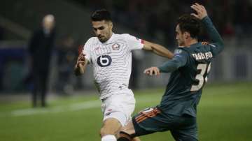 Lille's Zeki Celik, left, and Ajax's Nicolas Tagliafico vie for the ball during the group H Champions League soccer match between LOSC Lille and Ajax
