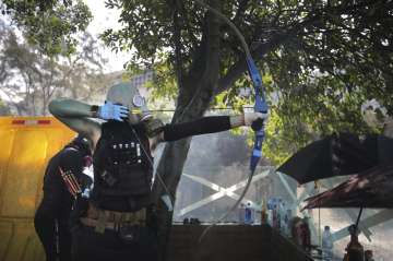 A protestor prepares to fire a bow and arrow during a confrontation with police at the Hong Kong Pol