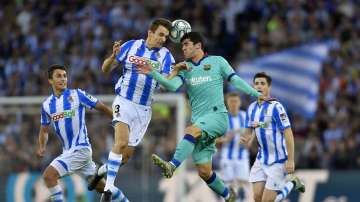 Barcelona's Carles Alena, center right, jumps for the ball with Real Sociedad's Diego Llorente during the Spanish La Liga soccer match between Real Sociedad and Barcelona