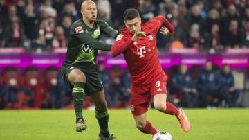 Bayern's Robert Lewandowski, right, and Wolfsburg's Marcel Tisserand battle for the ball during the Germany Bundesliga soccer match between Bayern Munich and VfL Wolfsburg.