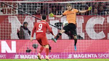 Leverkusen goalkeeper Lukas Hradecky, right, saves a shot from Bayern's Robert Lewandowski during their Bundesliga soccer match in Munich
