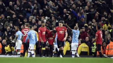 Players react to items thrown by Manchester City fans during the English Premier League soccer match between Manchester City and Manchester United at Etihad stadium 