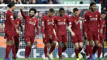Liverpool's Mohamed Salah, 3rd left, celebrates with teammates after scoring his sides first goal during the English Premier League soccer match between Liverpool and Watford at Anfield stadium in Liverpool