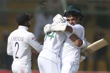 Pakistan's Abid Ali, right, celebrates his century with teammate Shan Masood against Sri Lanka during the third day of their second Test cricket match at National Stadium in Karachi