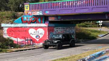 A vehicle drives by a tribute to victims of the Naval Air Station Pensacola that was freshly painted on what’s known as Graffiti Bridge in downtown Pensacola