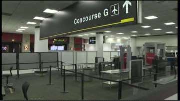 Unidentified woman strips naked at Miami Airport; arrested after mounting police car