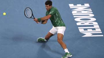 Serbia's Novak Djokovic makes a backhand return to Canada's Milos Raonic during their quarterfinal match at the Australian Open tennis championship in Melbourne