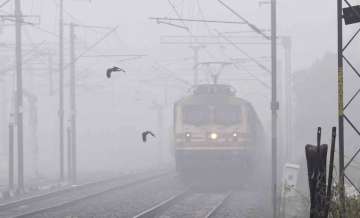  Patna: A train runs on its tracks amid a dense layer of fog during a cold winter morning