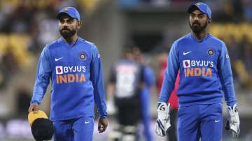 Virat Kohli of India holds a cap belonging to a pitch invader while KL Rahul looks on during game four of the Twenty20 series between New Zealand and India at Sky Stadium 