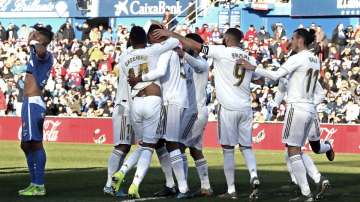 Real Madrid's Raphael Varane, third left, celebrates after scoring his side's opening goal during a Spanish La Liga soccer match between Getafe and Real Madrid.