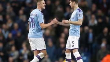 Manchester City's Taylor Harwood-Bellis, right, celebrates scoring his side's third goal of the game with teammate John Stones during the English FA Cup third round