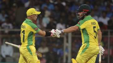 Australia's captain Aaron Finch, right, and David Warner cheer each other as they bat during the first one-day international cricket match between India and Australia in Mumbai