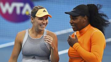 Denmark's Caroline Wozniacki, left, and Untied States' Serena Williams talk during their first round doubles match