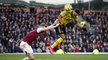 Arsenal's Pierre-Emerick Aubameyang, right, and Burnley's Ben Mee battle for the ball during the English Premier League soccer match at Turf Moor, Burnley