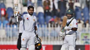 Pakistan batsman Babar Azam, right, celebrates after completing his century as his teammate Asad Shafiq claps during the second day of the 1st test cricket match against Bangladesh at Rawalpindi cricket stadium in Rawalpindi