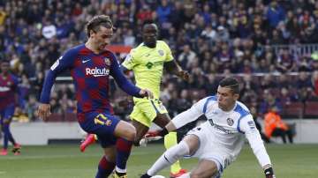 Barcelona's Antoine Griezmann, left, prepares to shoot past Getafe's goalkeeper David Soria to score his side's opening goal during a Spanish La Liga soccer match between Barcelona and Getafe at the Camp Nou stadium in Barcelona