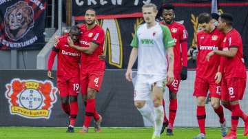 Leverkusen's Moussa Diaby, left, celebrates with Jonathan Tah, second from left, after scoring his side opening goal during the German Bundesliga soccer match between Bayer Leverkusen and FC Augsburg in Leverkusen, Germany, Sunday, Feb. 23