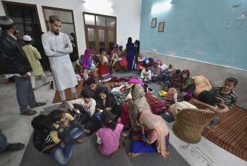 People take refuge at a residence in Chaman Park area of Mustafabad in Northeast Delhi, Friday (PTI)