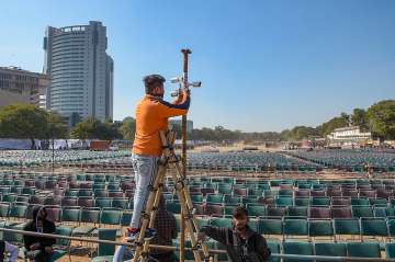 A worker installs CCTV cameras at Ramlila Maidan ahead of the oath-taking ceremony of Aam Aadmi Party (AAP)'s government, in New Delhi on Friday