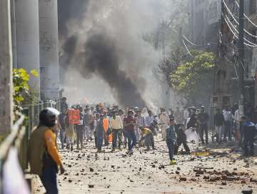 Protestors throw brick-bats during clashes between a group of anti-CAA protestors and supporters of the new citizenship act, at Jafrabad in north-east Delhi, Monday (PTI)