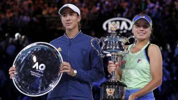 Sofia Kenin, right, of the U.S. holds the Daphne Akhurst Memorial Cup after defeating Spain's Garbine Muguruza in the women's singles final at the Australian Open tennis championship in Melbourne