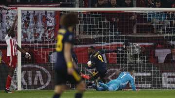 Arsenal's Alexandre Lacazette, second right, runs with the ball after scoring the opening goal of his team against Olympiakos during the Europa League round of 32, first leg, soccer match between Olympiakos and Arsenal at the Georgios Karaiskakis stadium in Piraeus port, near Athens, Thursday, Feb. 20
